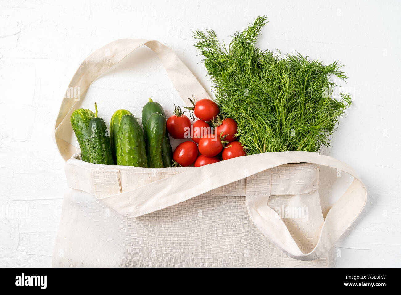 Verduras Frescas laicos plana en el eco cero residuos textiles reutilizables bolsa de compras sobre fondo blanco, con orientación horizontal. Foto de stock