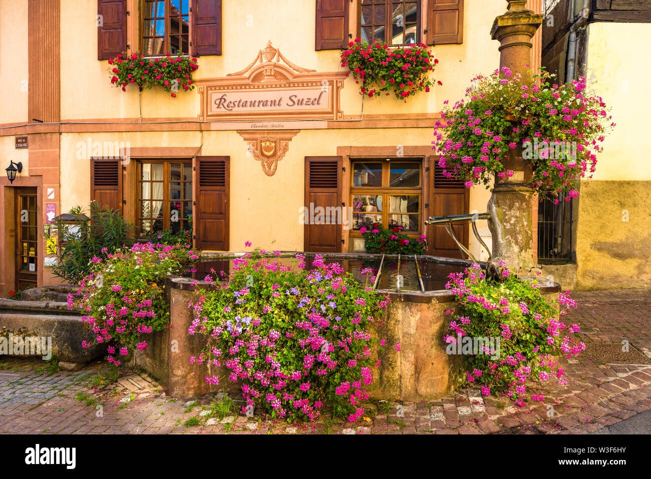 Antiguo y pintoresco con una exuberante decoración floral en Hunawihr, típico para la ruta del vino de Alsacia, Francia, miembro de los pueblos más bellos de Francia Foto de stock
