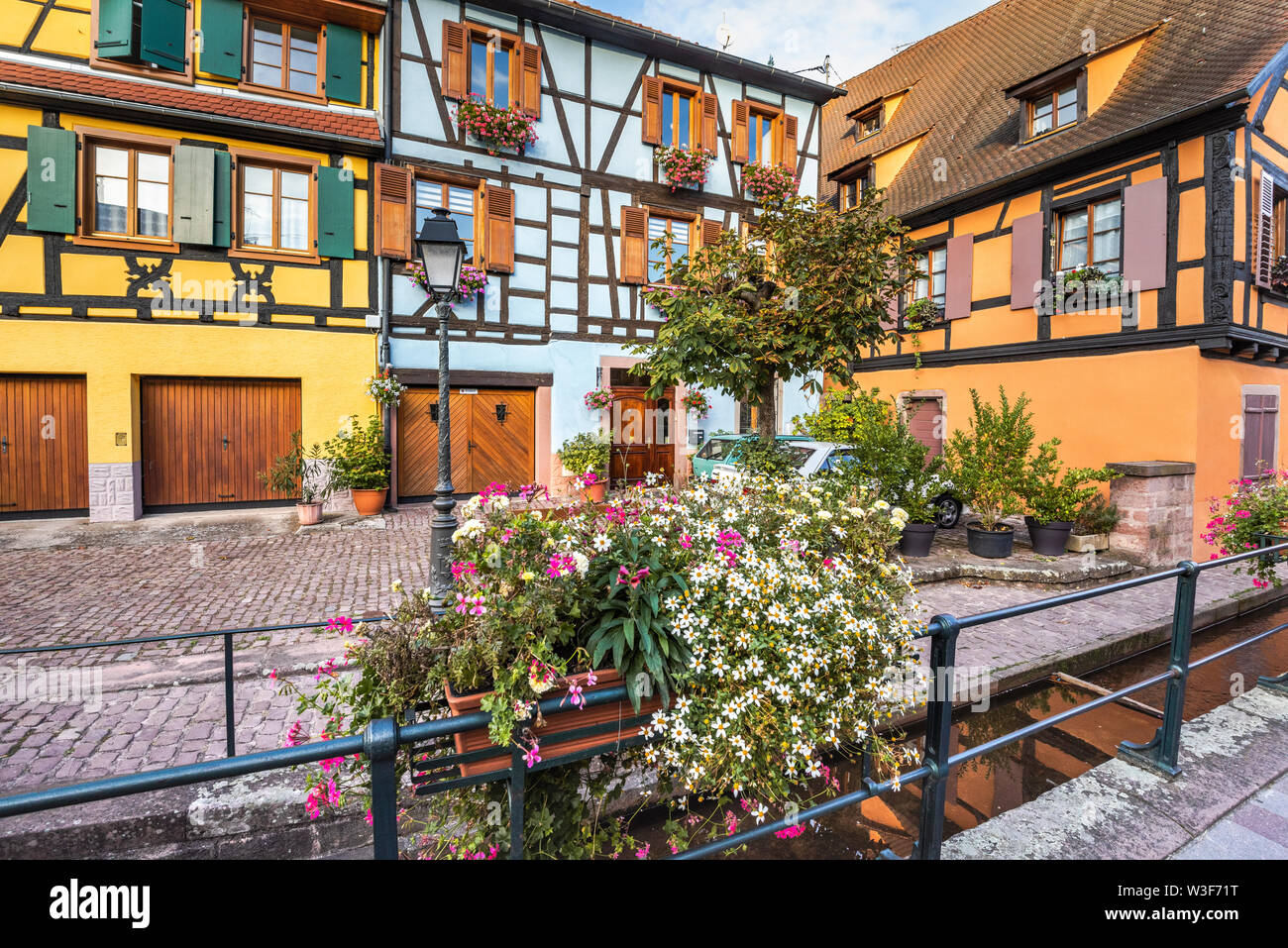 Aldea Ribeauvillé, Ruta del Vino de Alsacia, Francia, esquina con pintorescas casas con entramados de madera y floridos brook Foto de stock