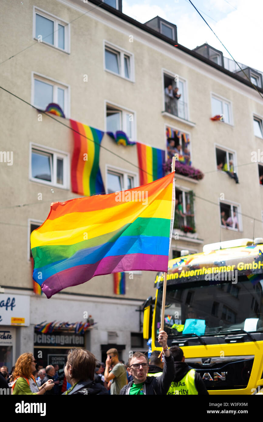 Menschen feiern den CSD in München auf der Müllerstraße 2019 mit der Regenbogenflagge für Gleichberechtigung der LGBT Community Foto de stock