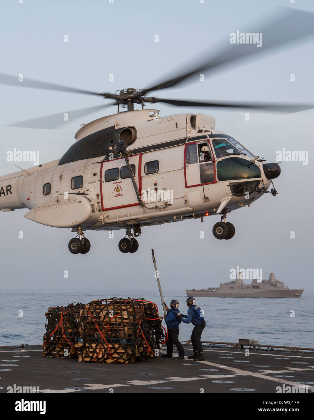 190701-M-QS181-1226 Golfo de Adén (Junio 30, 2019) un comando de Transporte Marítimo Militar SA-330J helicóptero Puma levantar cargas de carga desde el Harpers Ferry dock aterrizaje anfibio clase buque USS Harpers Ferry (LSD 49) durante un reabastecimiento vertical en alta mar. El boxeador Amphibious Ready Group y la 11ª MEU se despliegan en los EE.UU. 5ª Flota de la zona de operaciones en apoyo de las operaciones navales para garantizar la estabilidad y la seguridad marítima en la Región Central, que conecta el Mediterráneo y el Pacífico a través del Océano Índico occidental y tres estratégicos puntos críticos. (Ee.Uu. Marine Corps foto por CPL. Jason Monty) Foto de stock