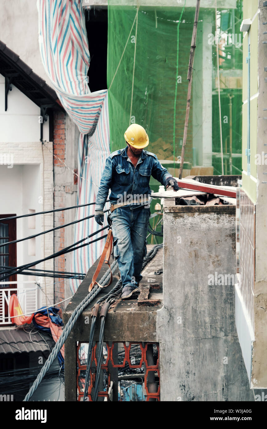 Trabajador de electricidad escalar alto en el techo de la casa de  reparación de la red de electricidad, el hombre tirar cable eléctrico para  el trabajo a las 12.00 horas, en la