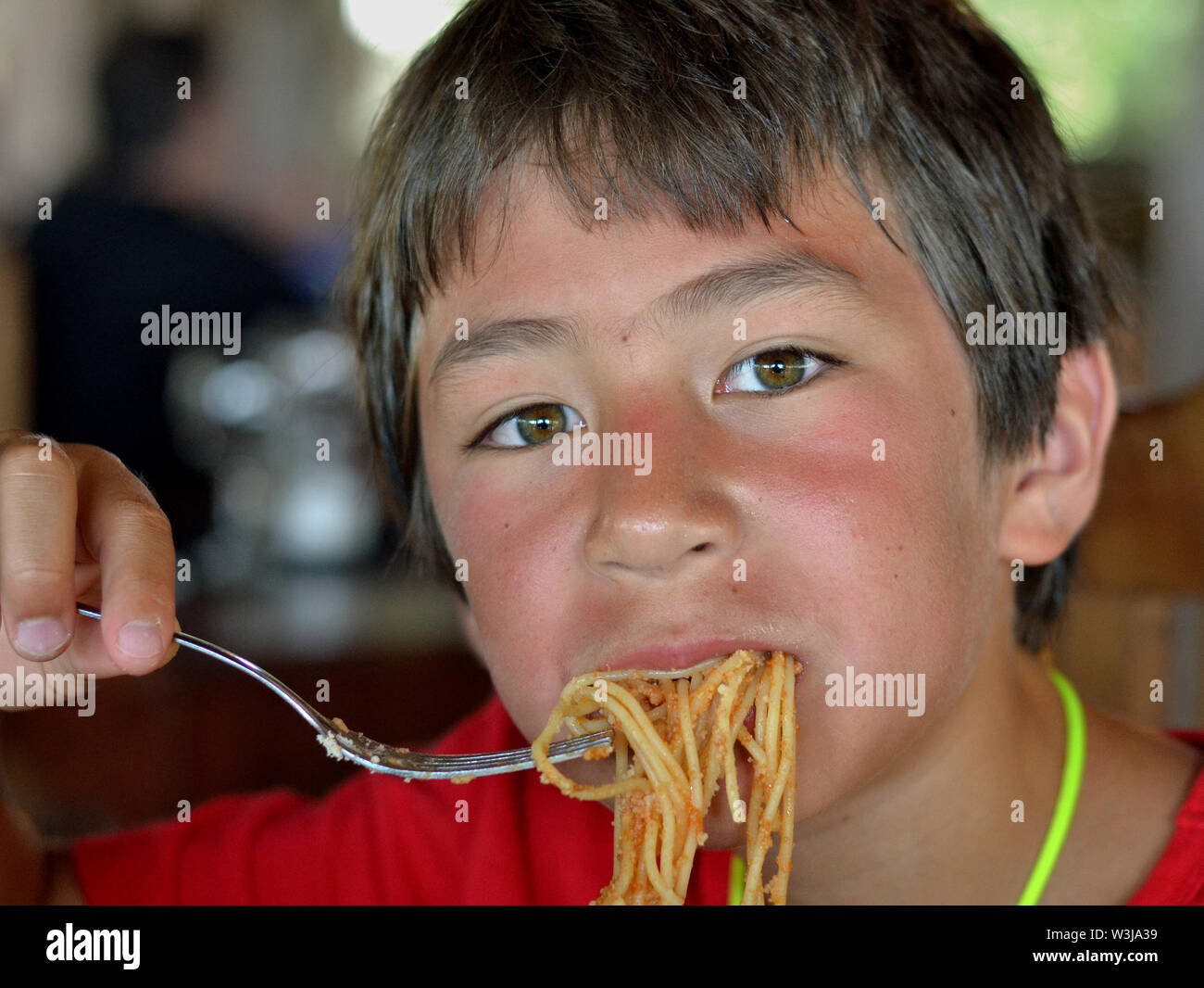 Cute Canadian mestizos boy come pasta. Foto de stock