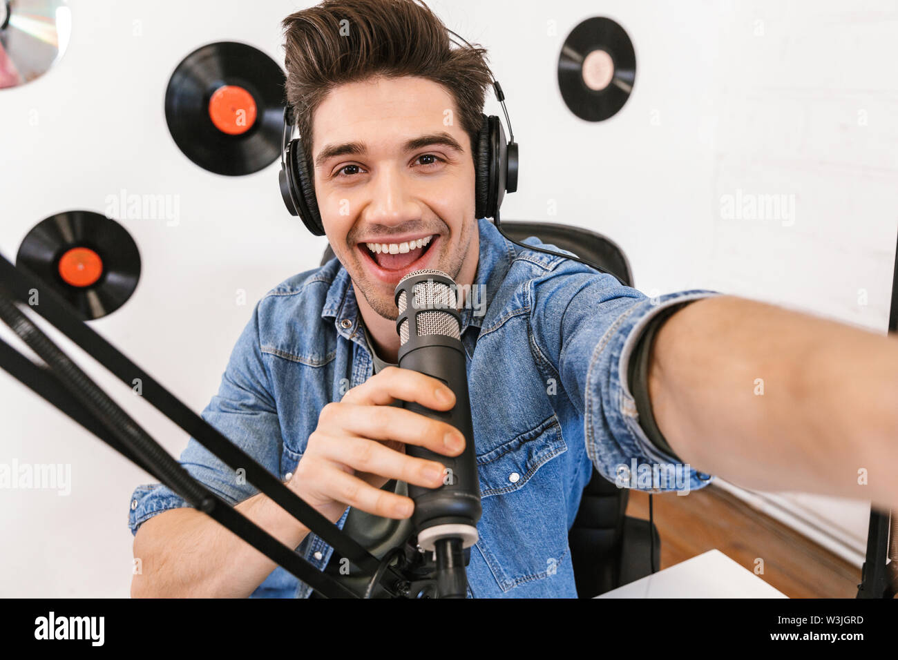 Imagen de un apuesto joven locutor de radio en el área de trabajo con el  equipo de sonido y micrófono tomar selfie por cámara Fotografía de stock -  Alamy