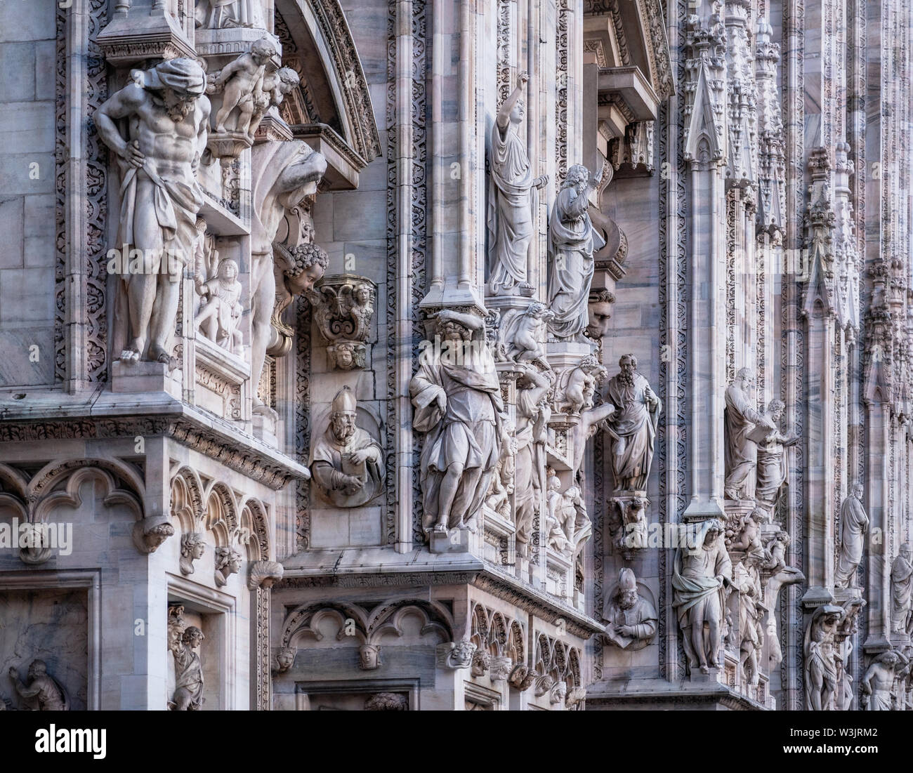 Fachada de la Catedral con detalles de mármol, estatuas y obras, Milán, Italia, Foto de stock