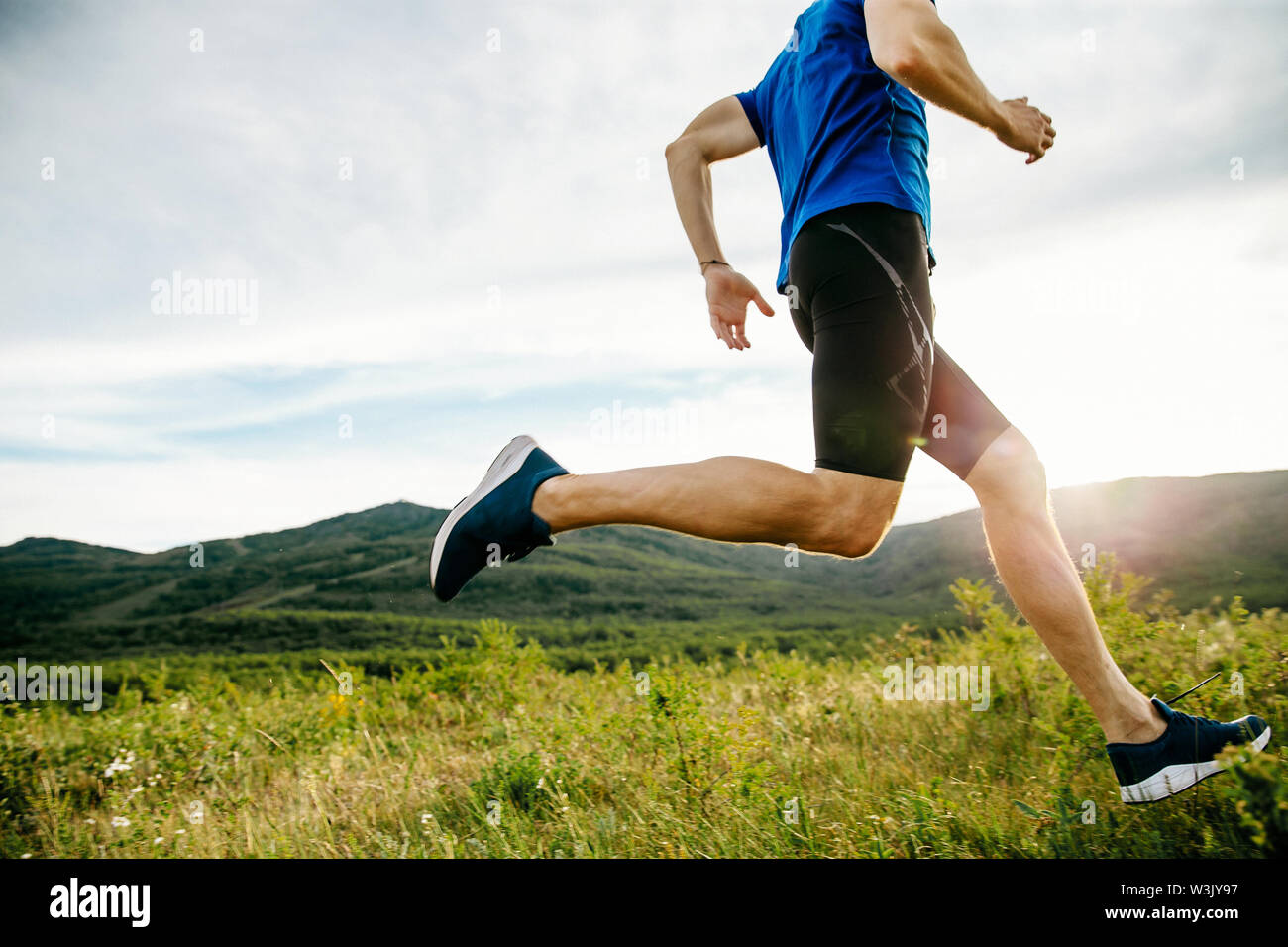 Atleta runner ejecute en la meseta de la montaña de verano en Sunset Foto de stock