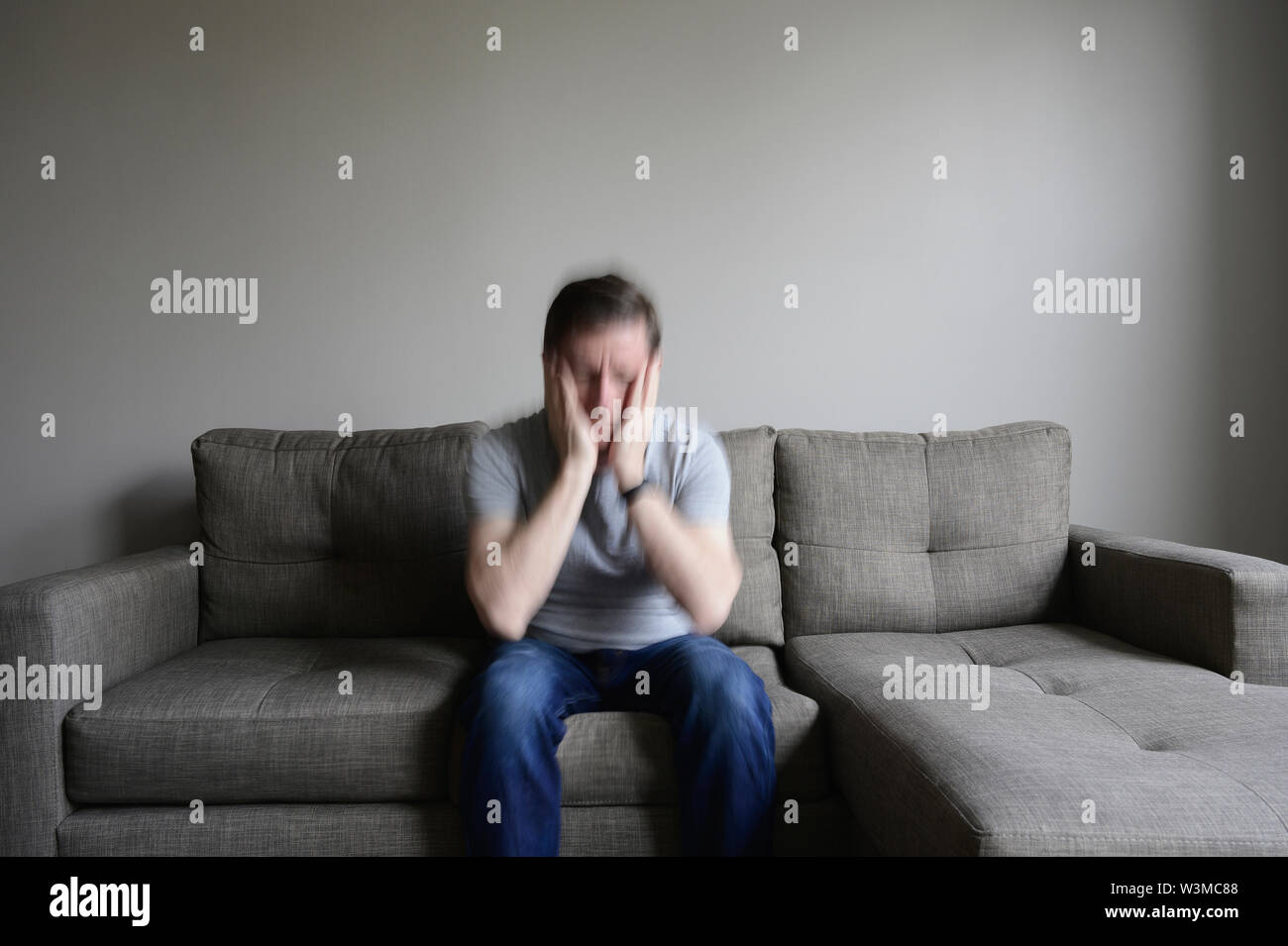 Hombre maduro deprimido sentado en el sofá Foto de stock
