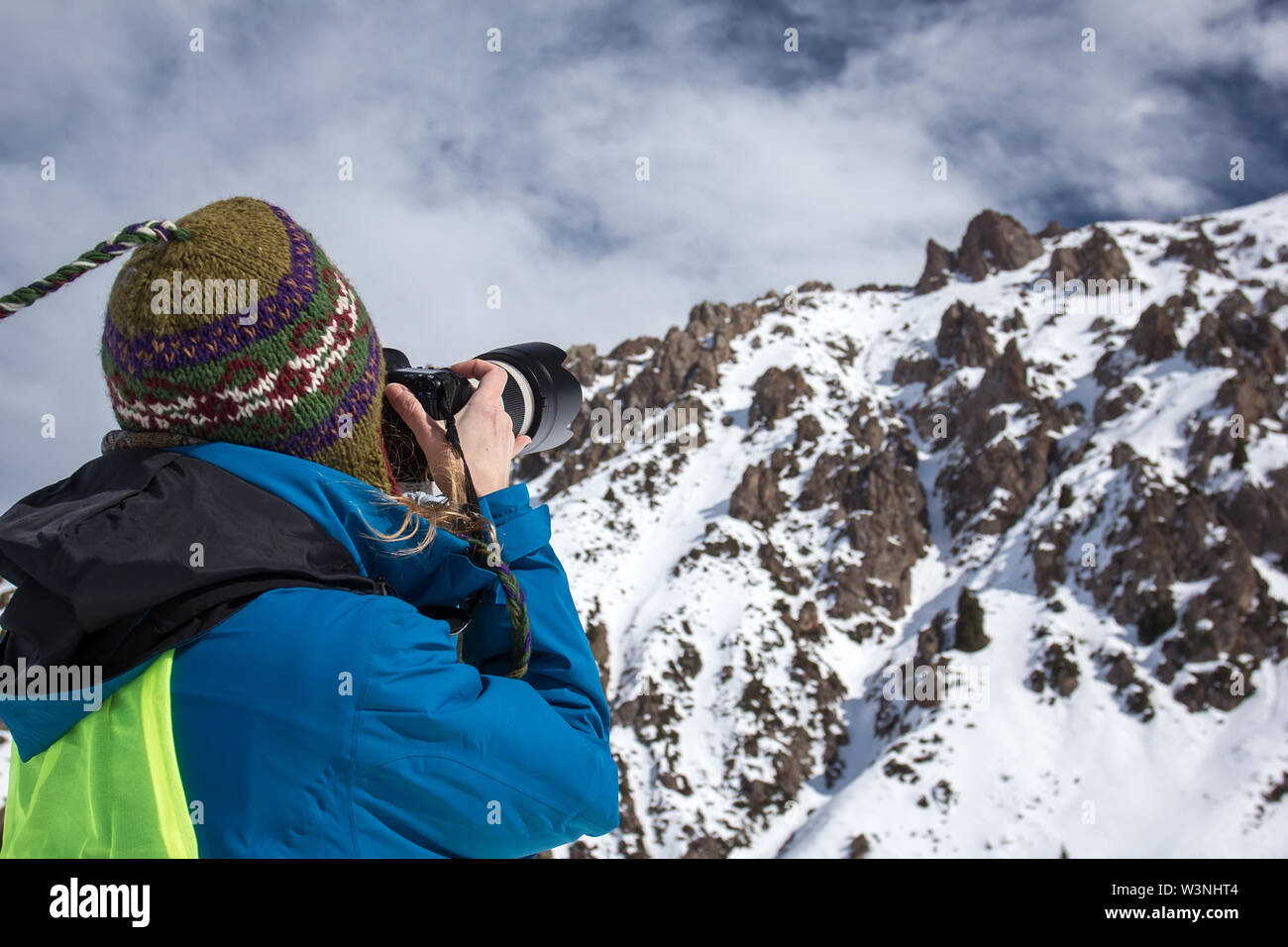 Concepto de fotografía de la naturaleza. Fotógrafo profesional toma fotos del pico de la roca. Paisaje invernal. Foto de stock
