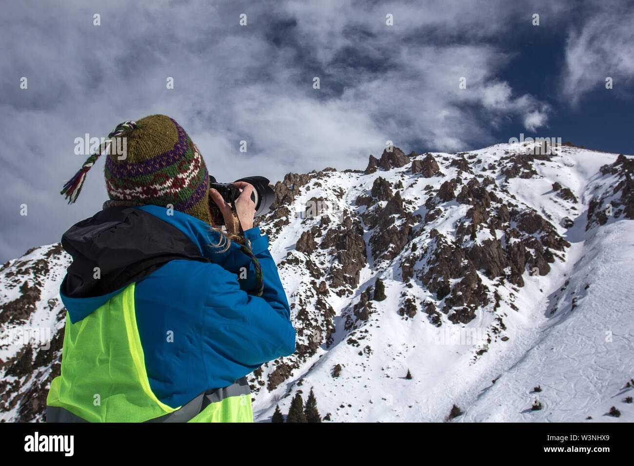 Concepto de fotografía de la naturaleza. Fotógrafo profesional toma fotos del pico de la roca. Paisaje invernal. Foto de stock