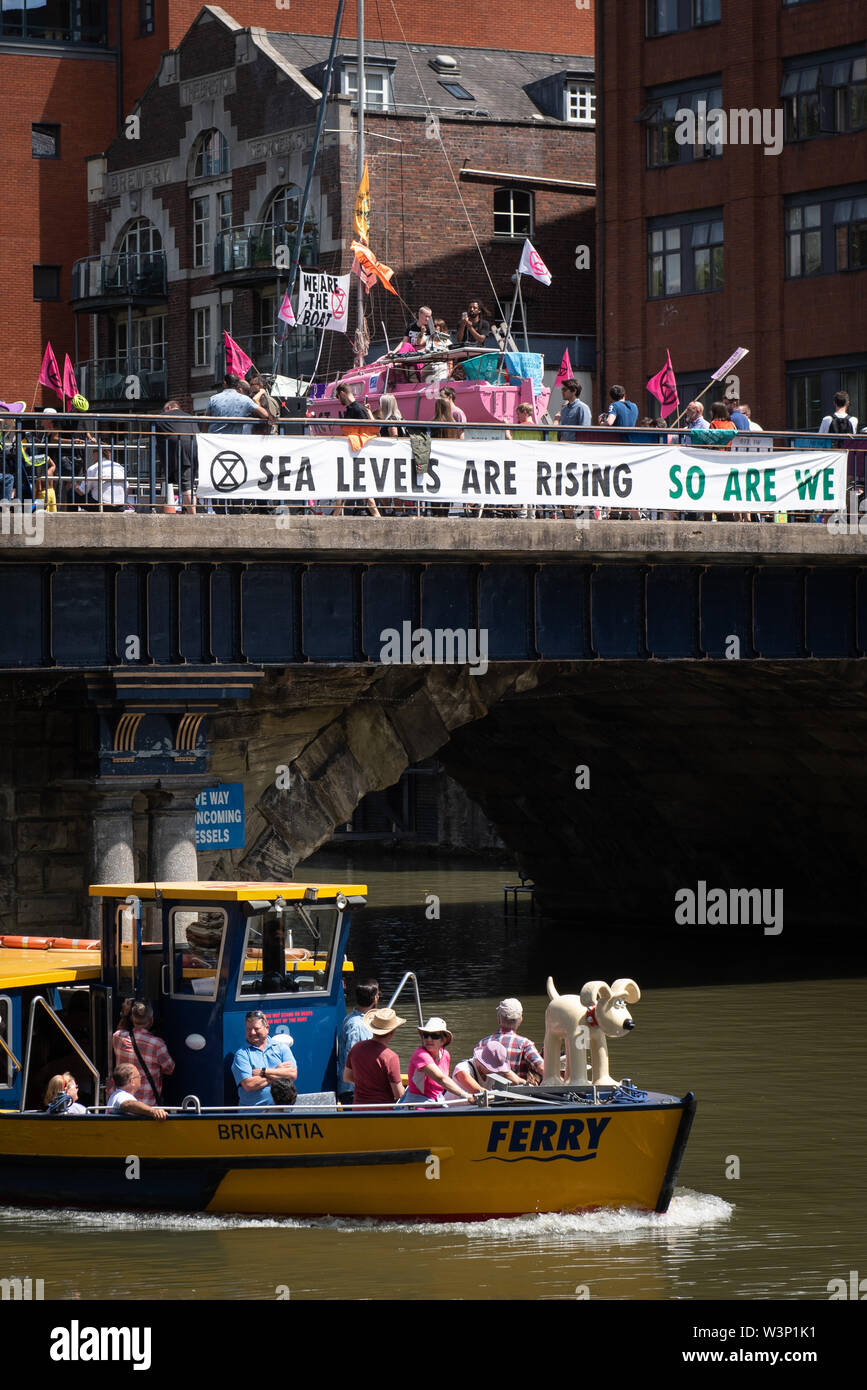 Bristol, Reino Unido. El 15 de julio de 2019. Cientos de extinción rebelión manifestantes bloquean Puente Bristol con un barco de vela rosa y marcha por las calles Foto de stock
