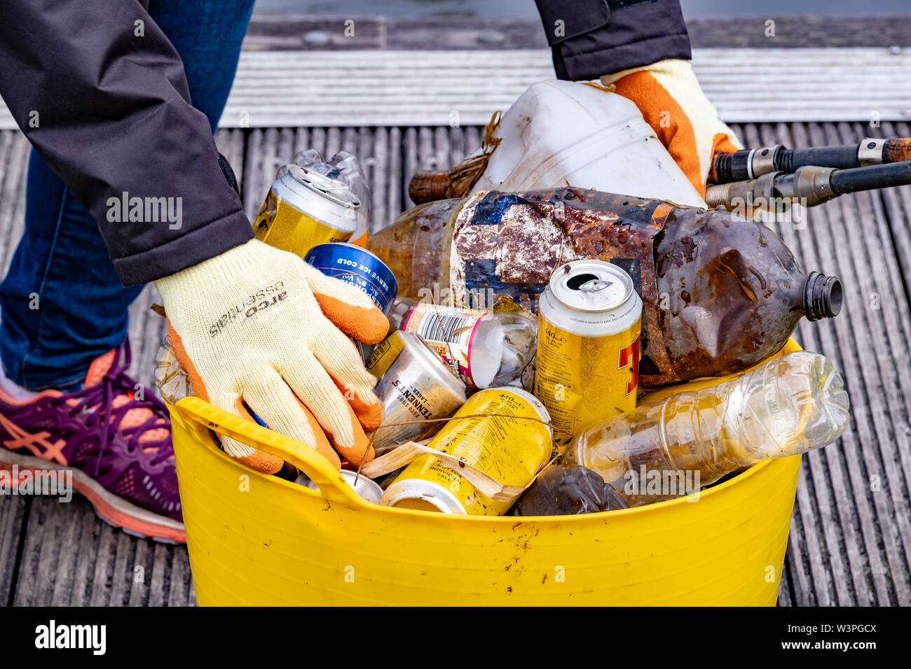 Los voluntarios recoger basura banco junto al canal. Foto de stock