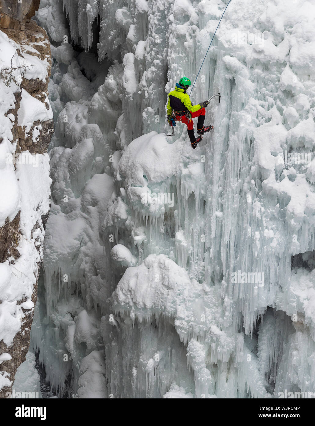 Parque Nacional de Banff, Alberta, Canadá - Enero 11, 2015: el escalador de hielo en una cascada congelada en Johnston Canyon Foto de stock