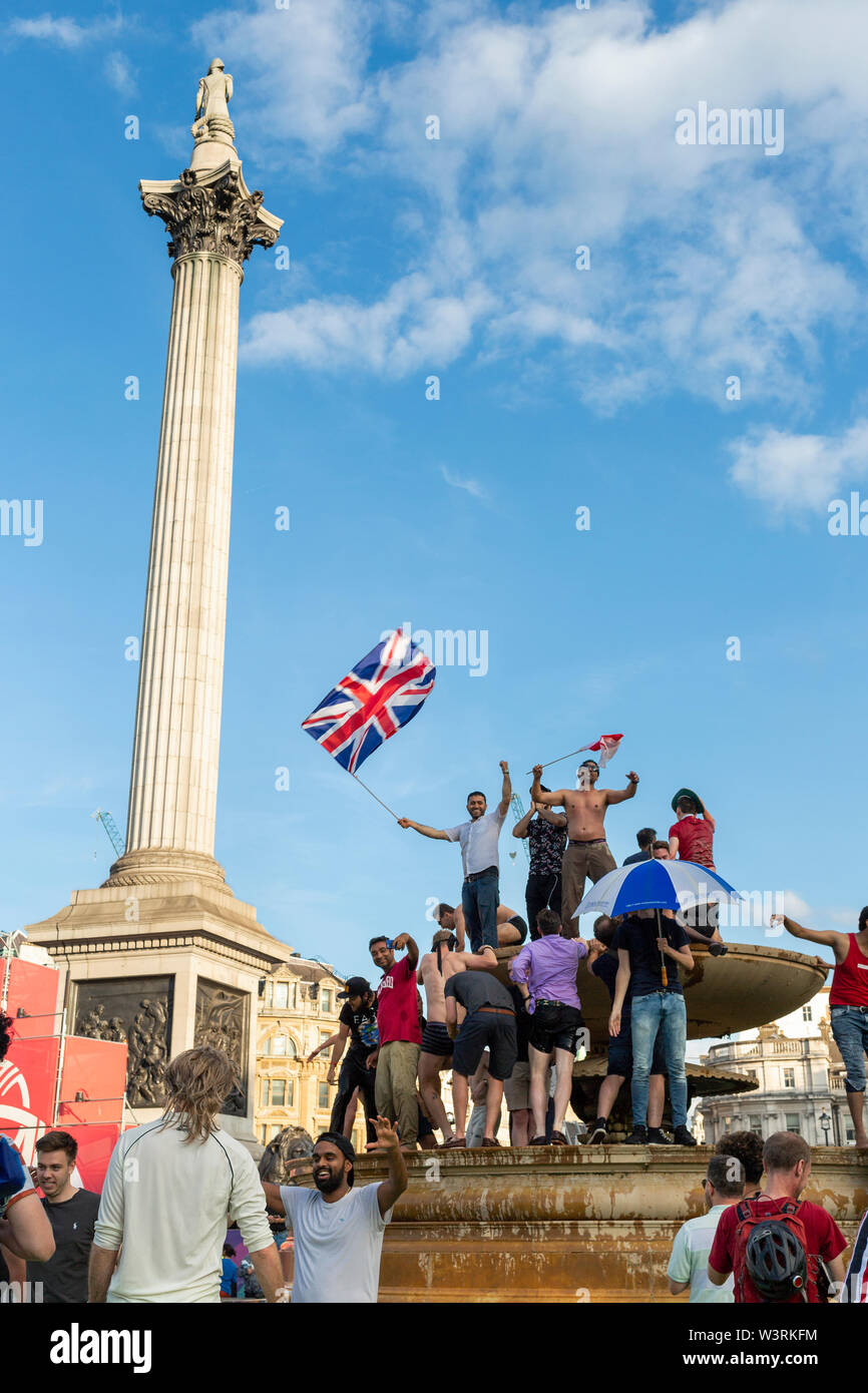 Londres, Reino Unido, 14 de julio de 2019 : eufóricos fans celebran en las fuentes at Trafalgar Square tras la victoria de Inglaterra en la ICC Cricket World Cup Foto de stock