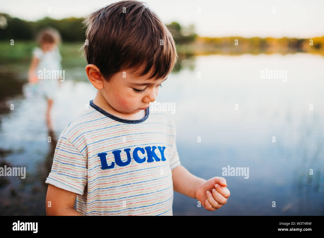 Primer plano de un joven de pie en el agua en el lago en verano Foto de stock