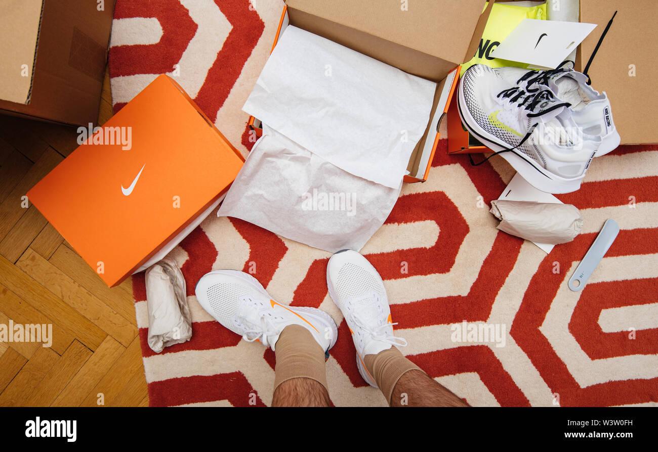 París, Francia - Jul 13 2019: hombre unboxing midiendo las nuevas zapatillas se equipo con caja de cartón fabricado por Nike logotipo blanco en el de la zapatilla
