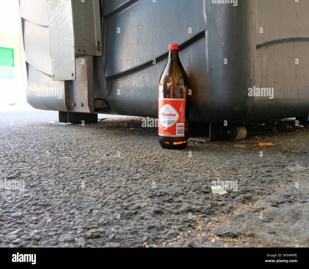 https://c8.alamy.com/compes/w3w4pe/una-botella-de-un-litro-de-cerveza-tradicional-alhmabra-abandonados-por-el-lado-de-la-calle-cerca-de-una-papelera-y-acera-en-granada-espana-w3w4pe.jpg