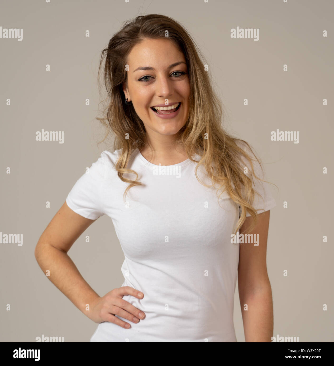 Cerrar retrato del joven atractiva mujer caucásica con cara feliz y bella sonrisa. Aislado sobre fondo neutro en personas, fa humana positiva Foto de stock