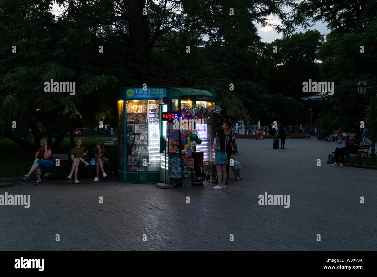 Ucrania, Odessa, Calle Deribasivska, 11 de junio de 2019. Un pequeño quiosco iluminada en el jardín de la ciudad al atardecer. Foto de stock