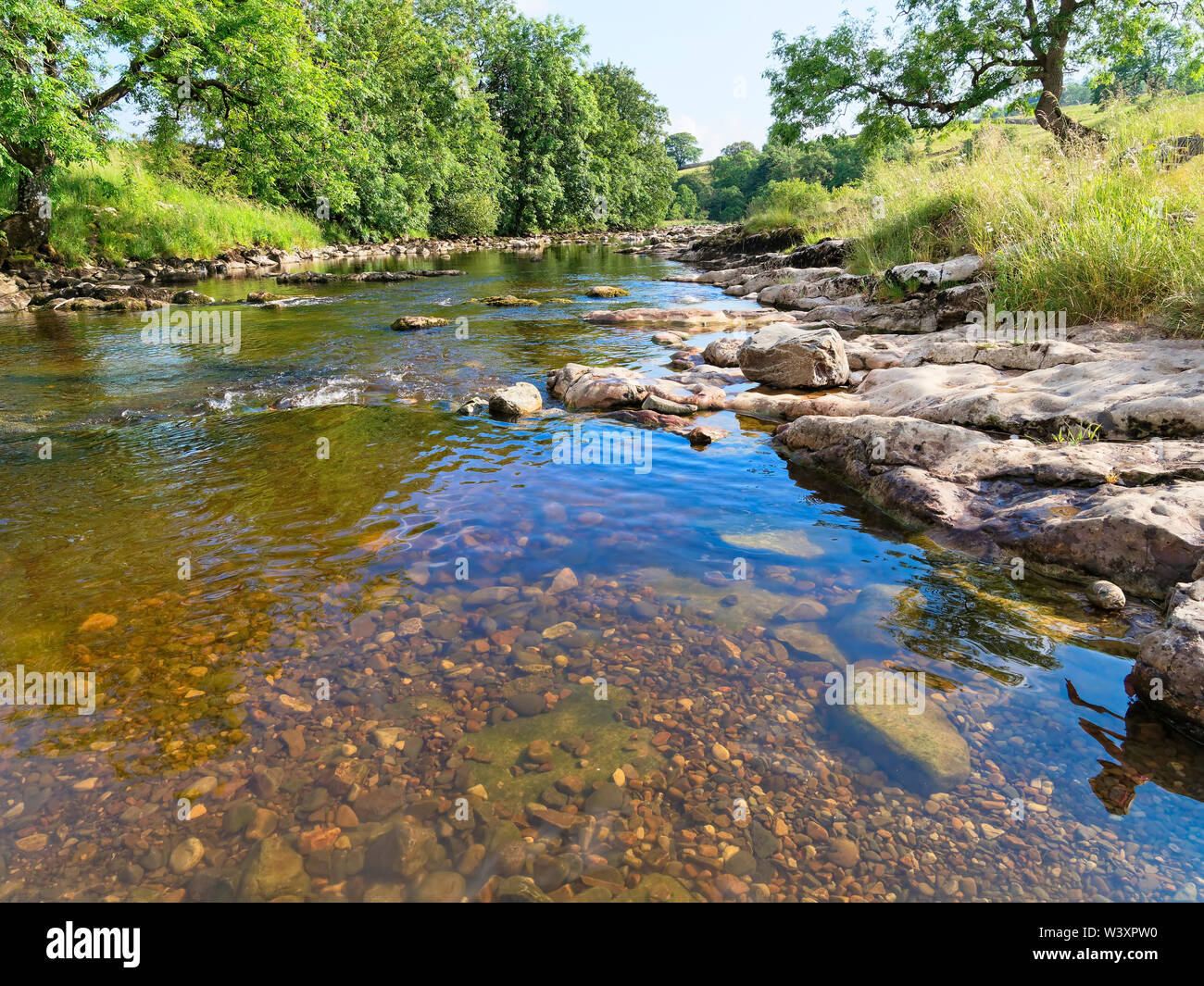El agua cristalina del río Ribble fluye suavemente a través de los valles de Yorkshire, cerca de la aldea de Stainforth Foto de stock