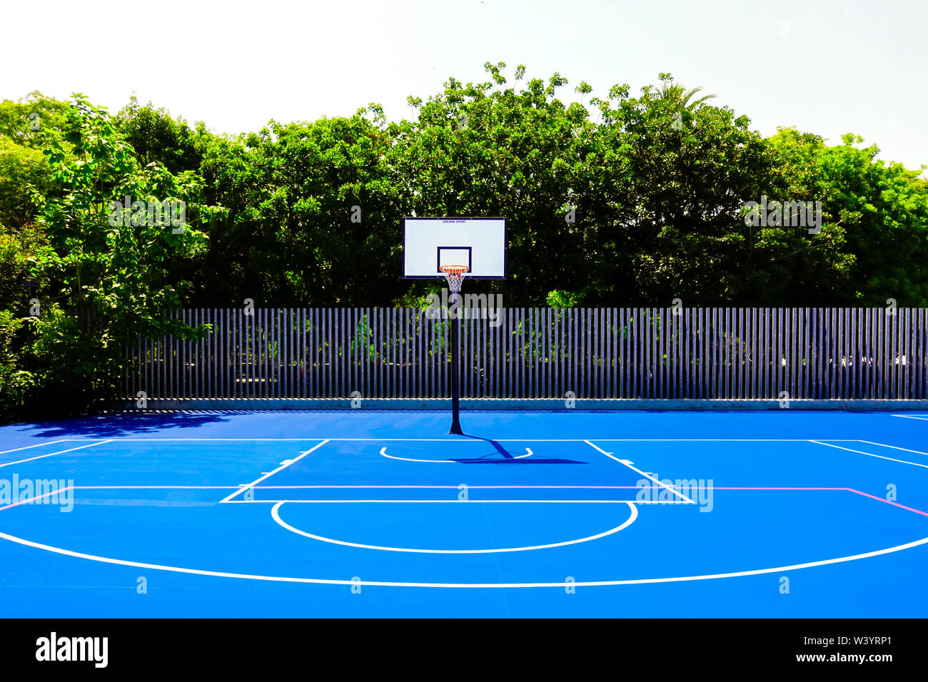 Cancha de baloncesto en un parque al aire libre, con un intenso sol de  mediodía, nadie, pintadas de azul y el suelo Fotografía de stock - Alamy