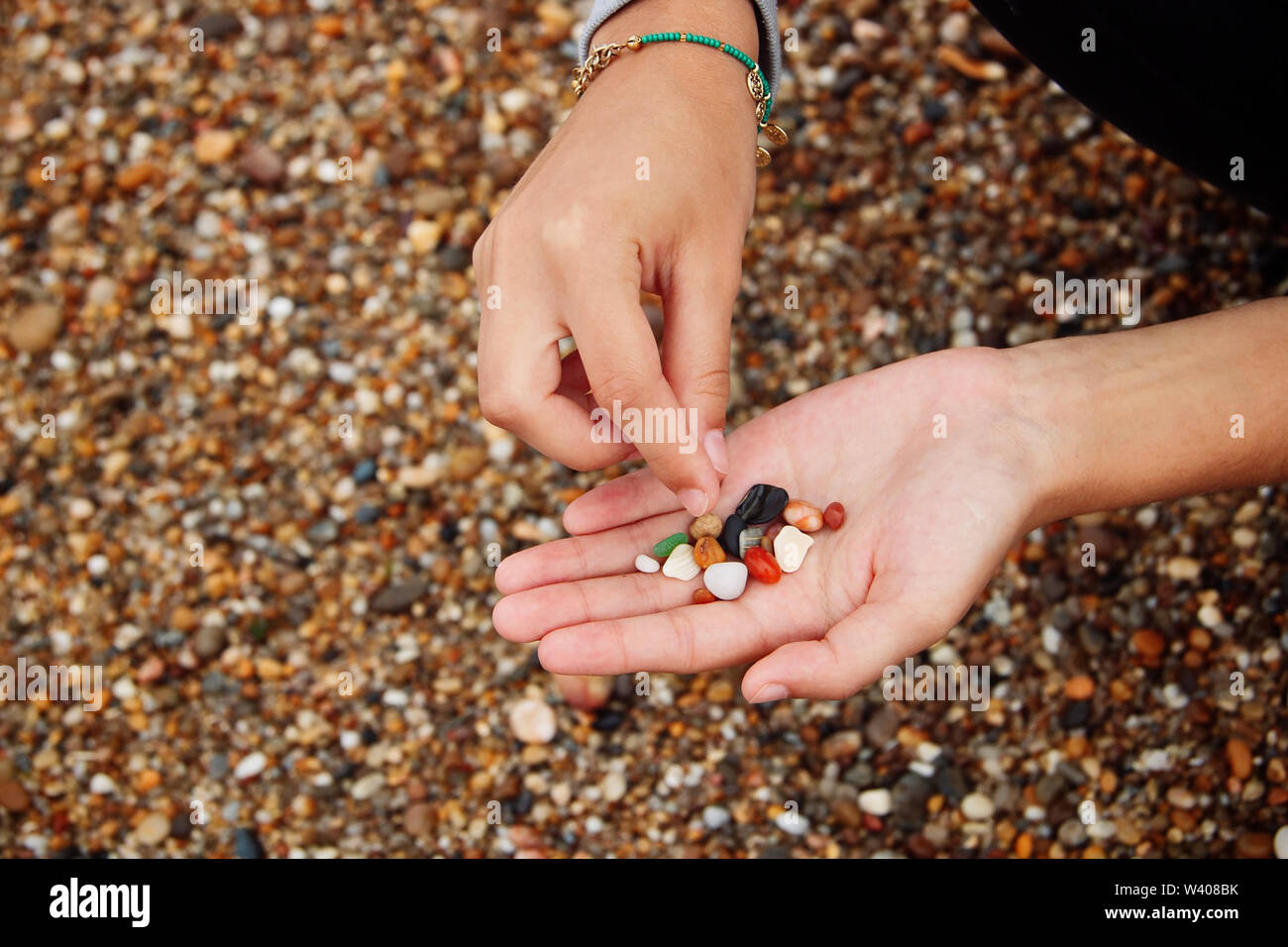 La recogida de la mano algunas piedras en la playa. Foto de stock