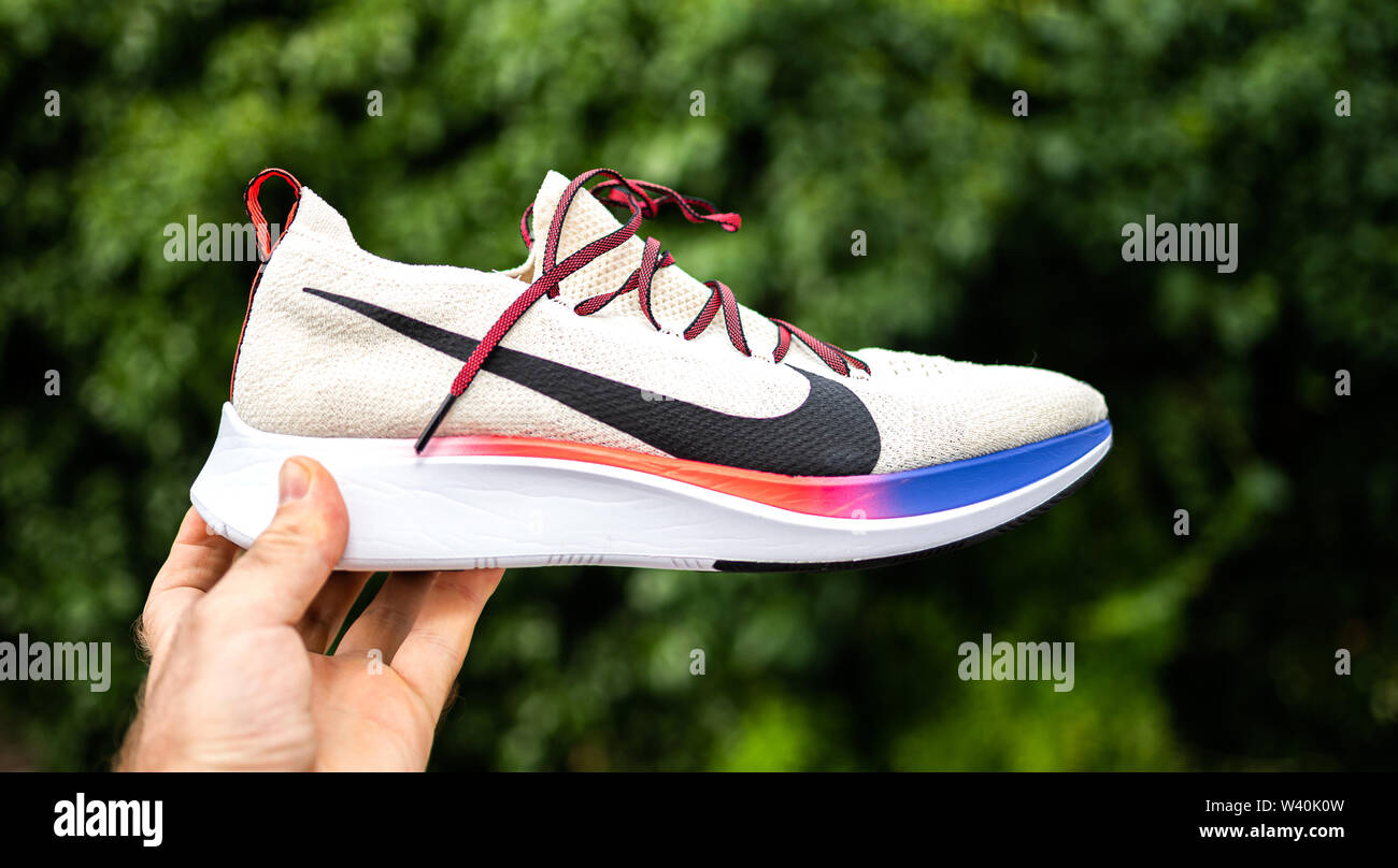 París, Francia - Jul 8, 2019: el atleta hombre mano sujetando presentando  nuevas zapatillas Nike Zoom Fly Flyknit contra fondo verde - Vista lateral  con logotipo insignia Fotografía de stock - Alamy