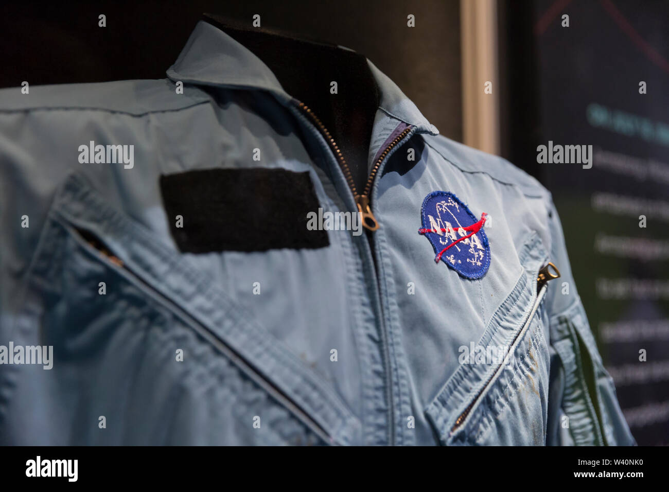 Chaqueta de vuelo de la NASA propiedad de Charles Bolden. Chaqueta de vuelo  azul con siete parches diferentes. Un parche de bandera americana aparece  en el hombro izquierdo apropiado de la chaqueta
