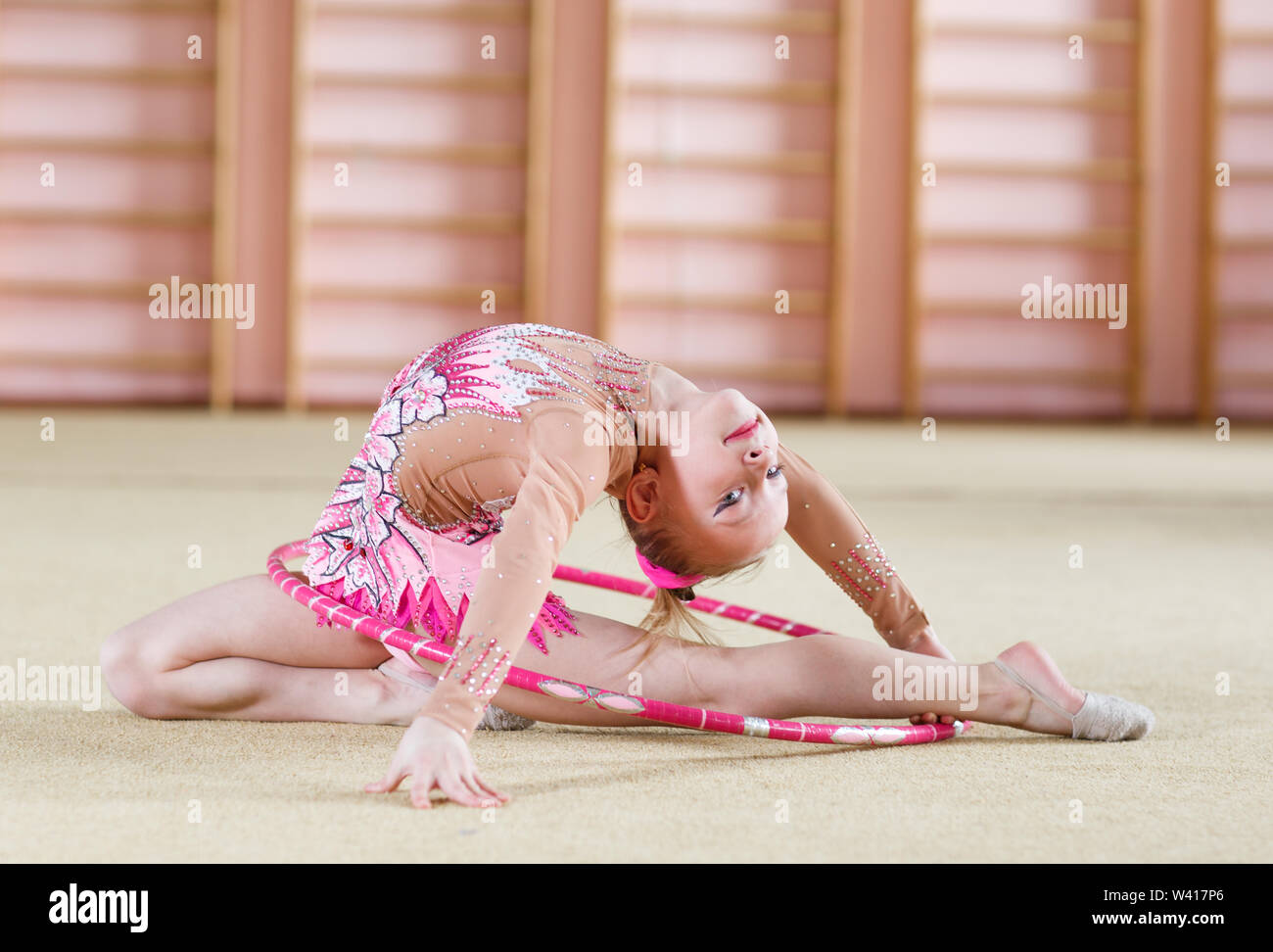 Niña pequeña haciendo gimnasia con aro Foto de stock 2109617015