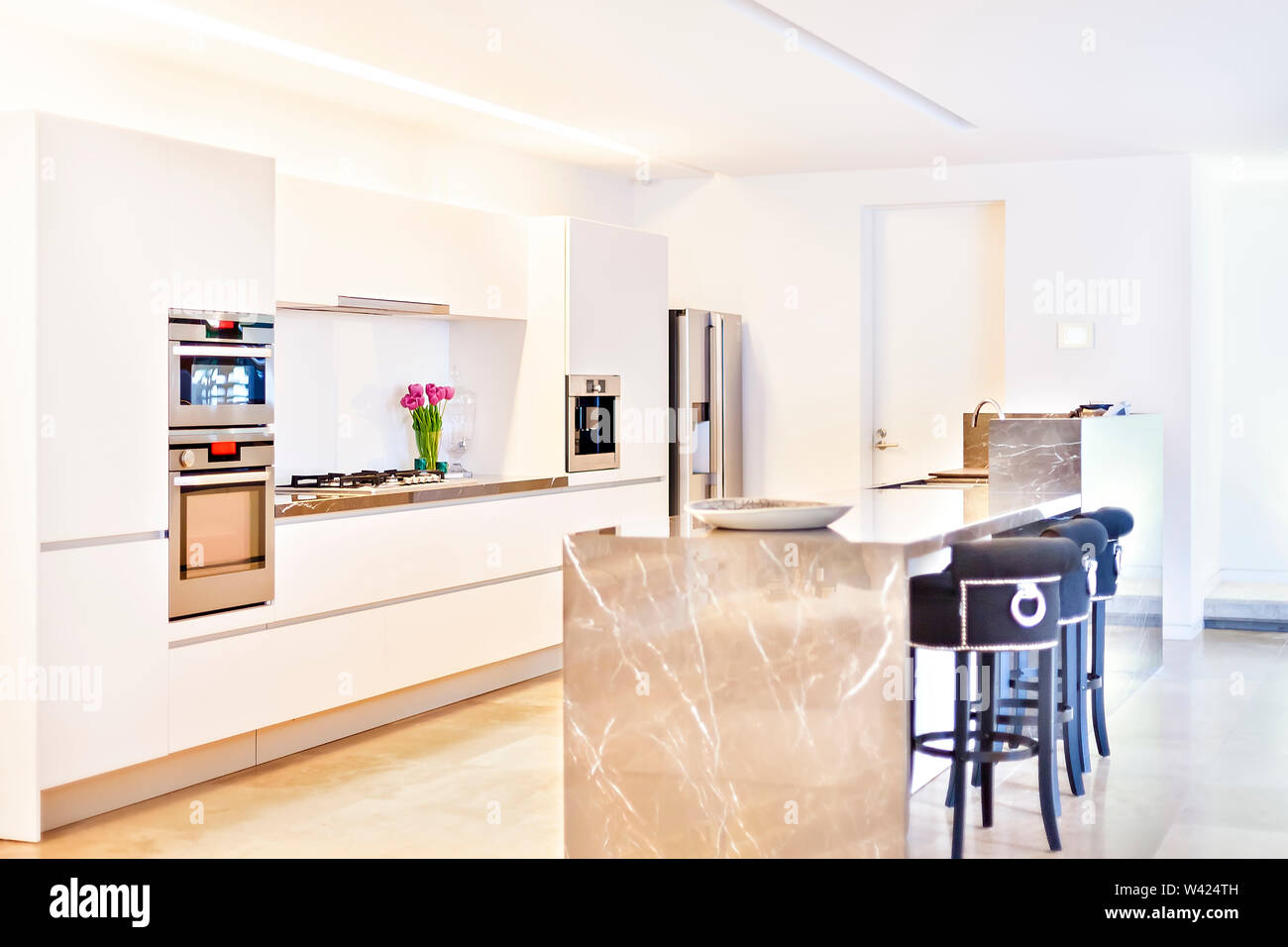 Moderna cocina de microondas y estufas junto al refrigerador con paredes  blancas que iluminados por la luz del sol Fotografía de stock - Alamy