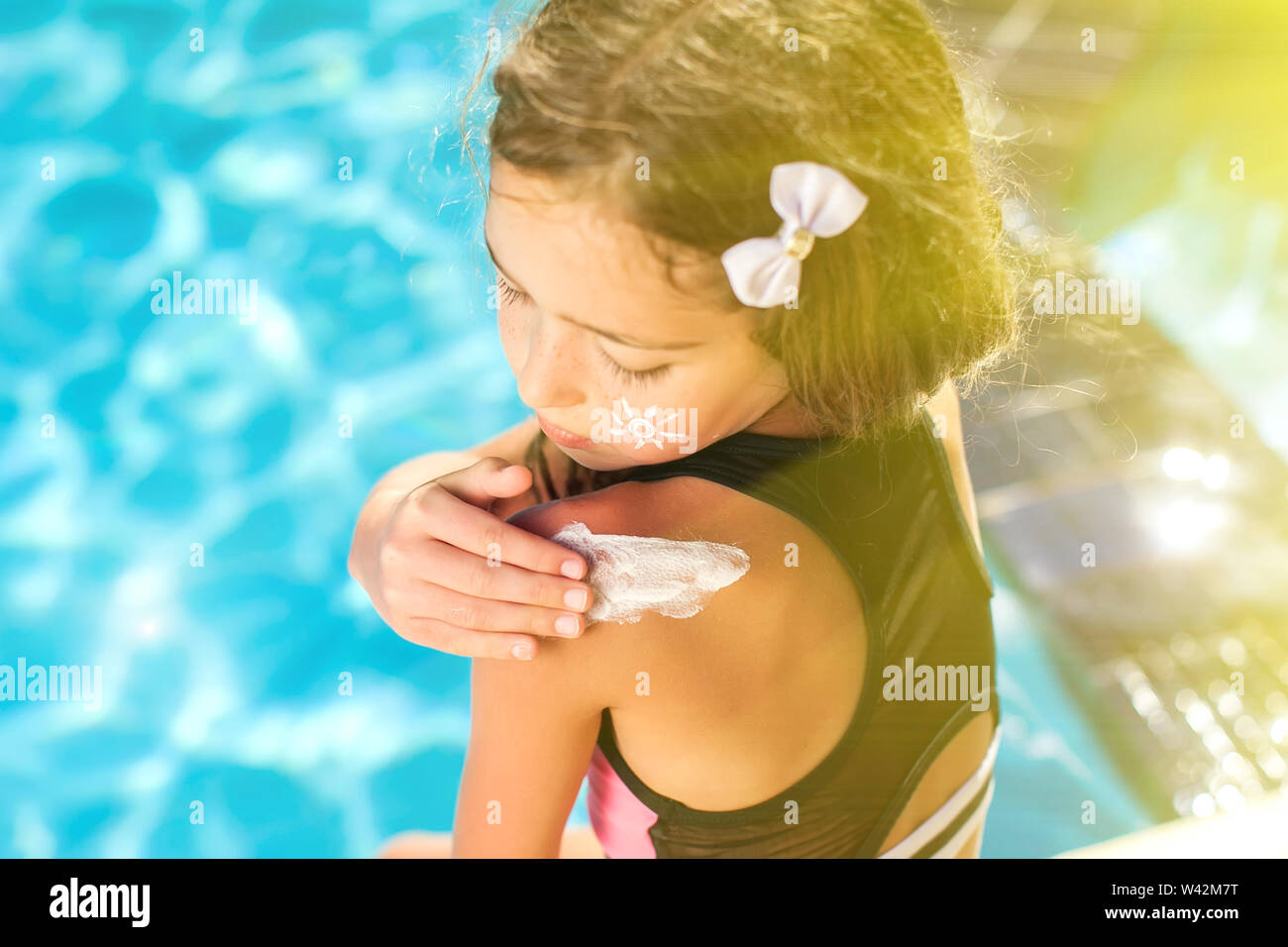 Chico Chica aplica crema de protección solar sobre la piel. Los niños, en verano y en concepto de asistencia sanitaria Foto de stock