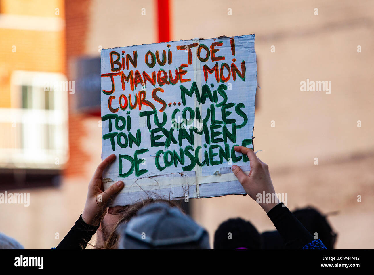 Una señal en Francés lee extraño mi clase, pero no su examen de conciencia  ambiental como los manifestantes de marzo en una calle de la ciudad contra  el calentamiento global Fotografía de