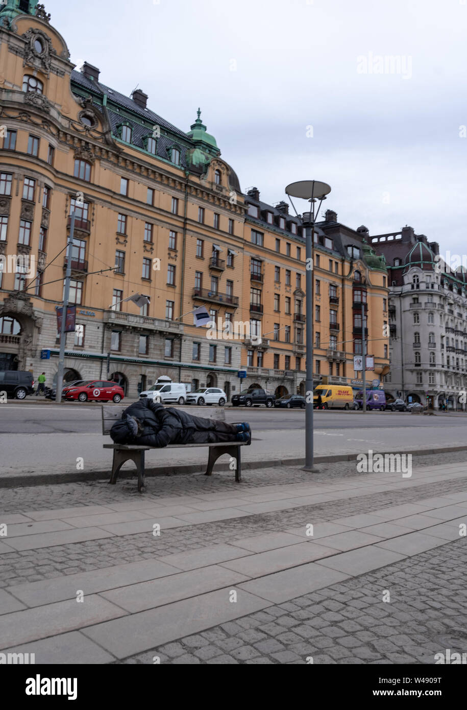 Estocolmo Suecia 28.03.2019 Editorial hombre durmiendo en un banco en la acera Foto de stock