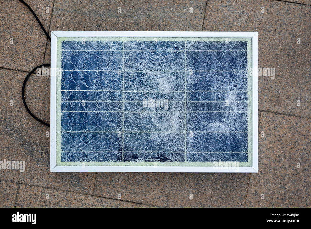 Panel solar roto es visto sobre el terreno durante una protesta contra la interferencia del gobierno en la industria. Foto de stock