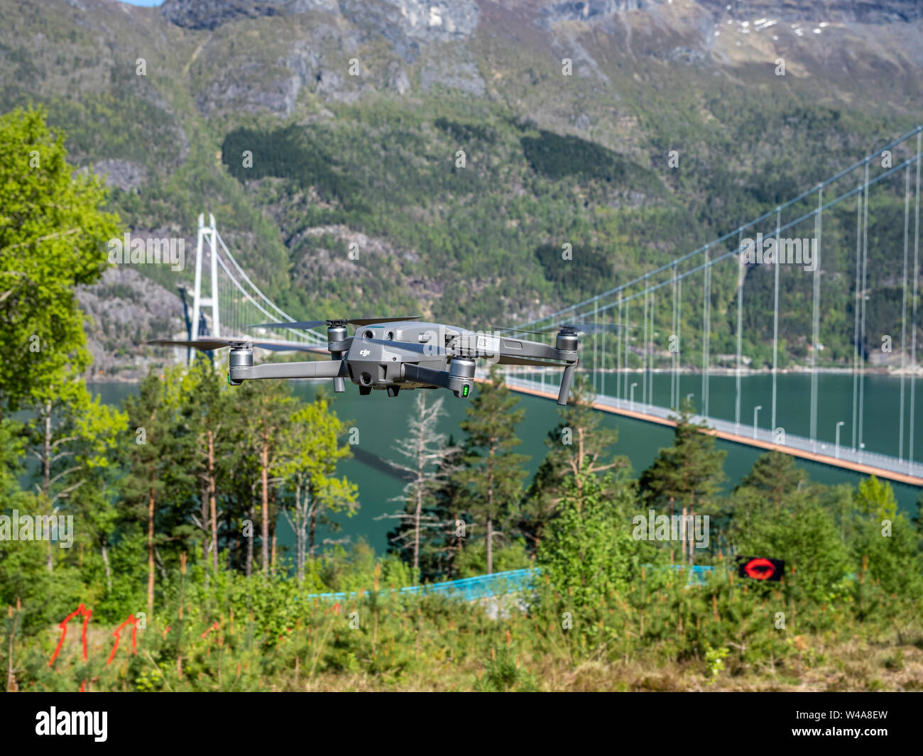 Drone volando cerca del puente colgante de Hardanger, puente Hardangerbrua durante la primavera, El Hardangerfjord, Hardanger, Noruega Foto de stock