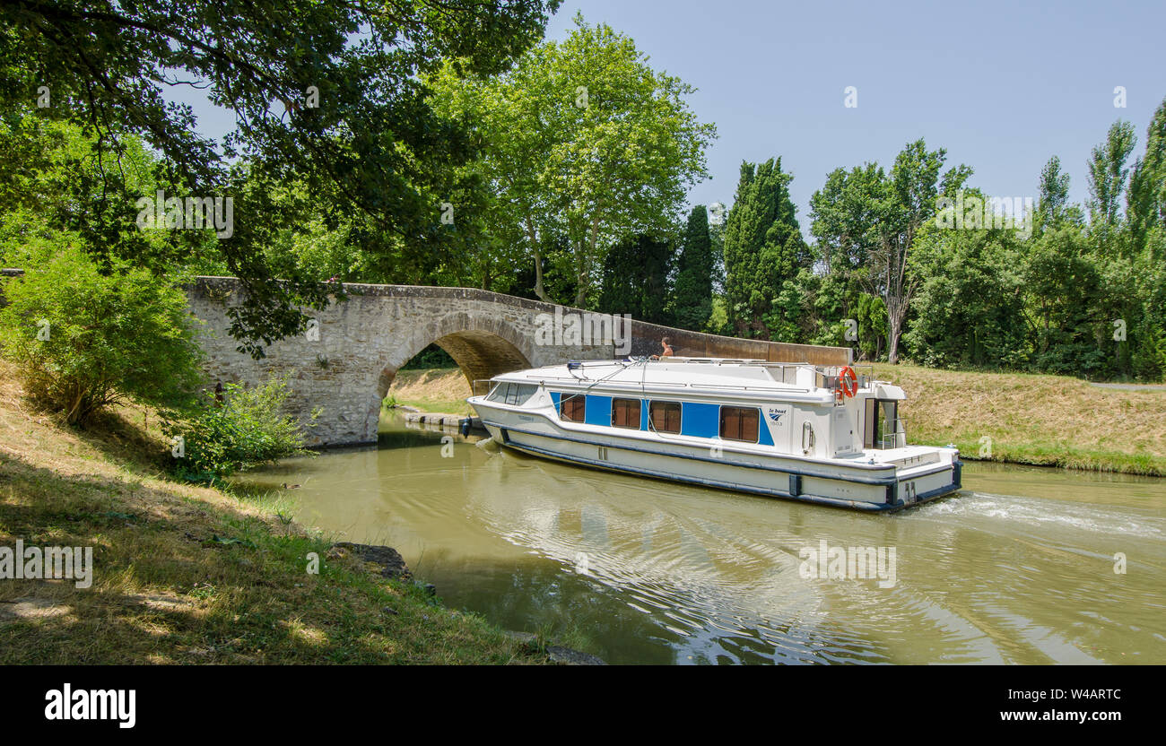 Un placer barco de crucero por el Canal du Midi, Francia, pasando por  debajo de un puente sobre el canal Fotografía de stock - Alamy