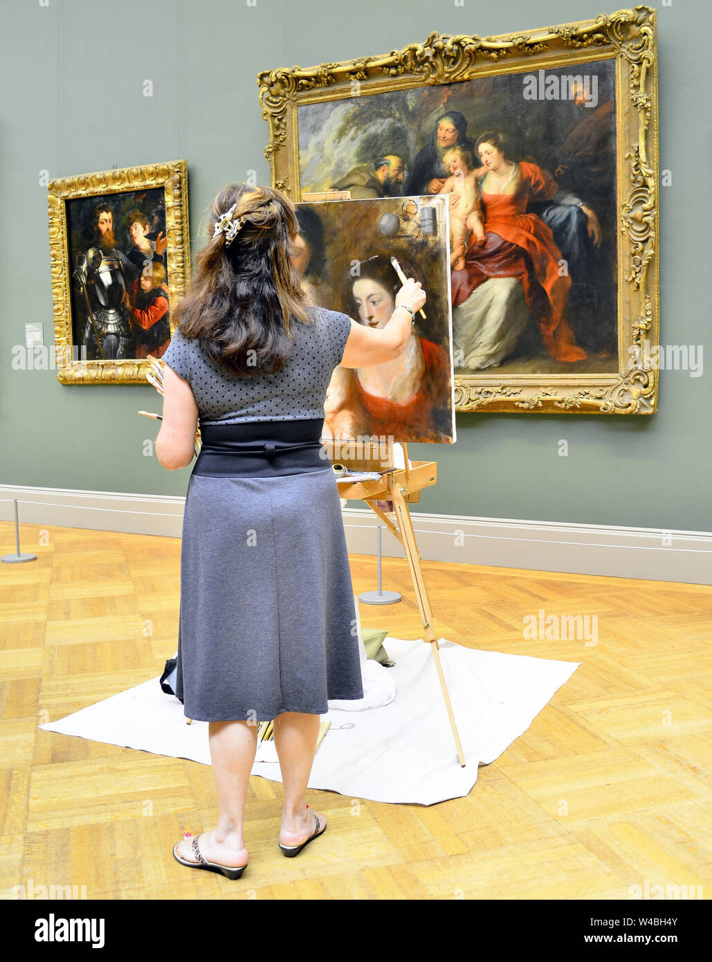 Mujer en el Museo de pinturas del artista al referirse a una obra maestra de pintura. Foto de stock