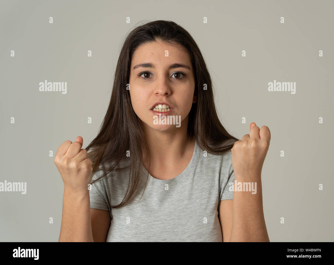 Cerca de jóvenes frustrados atractiva mujer latina en el estrés con cara furiosa. Mirando enojado y decepcionado haciendo gestos enojados. En punto muerto backgr Foto de stock