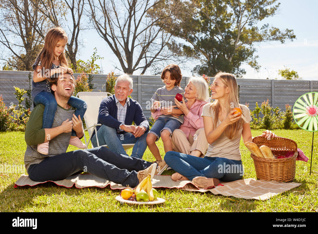 Feliz familia con niños y abuelos picnic en el jardín Foto de stock