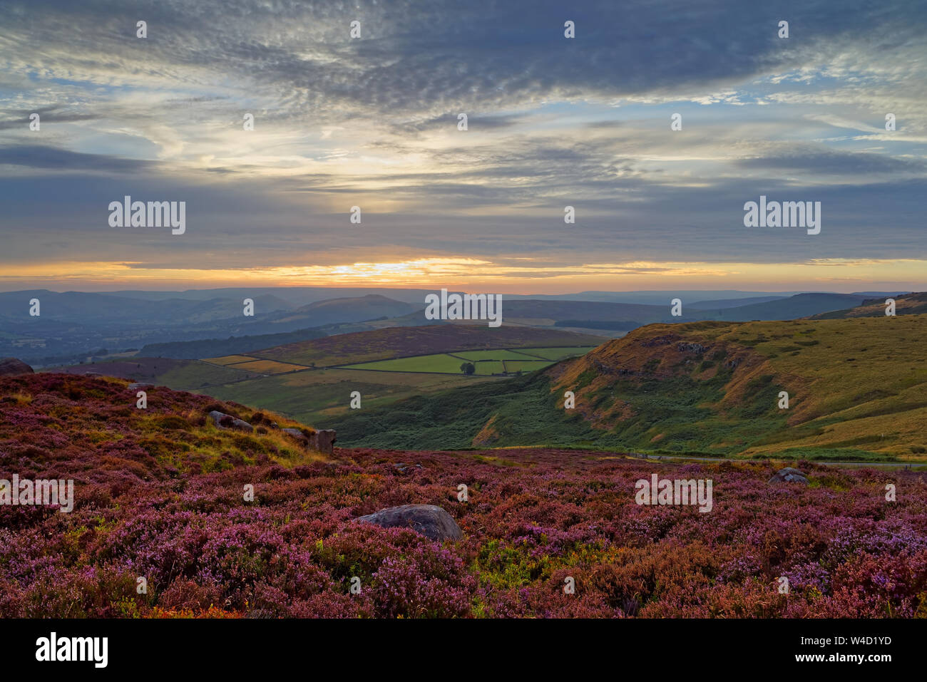 Reino Unido,South Yorkshire,Peak District, cerca de Sheffield, puesta de sol sobre el valle de esperanza Higger Tor con Heather en plena floración. Foto de stock