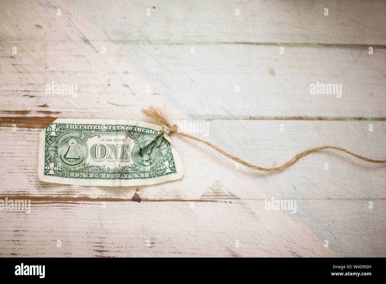 Dólar americano Bill atado al extremo de un trozo de cuerda. Foto de stock