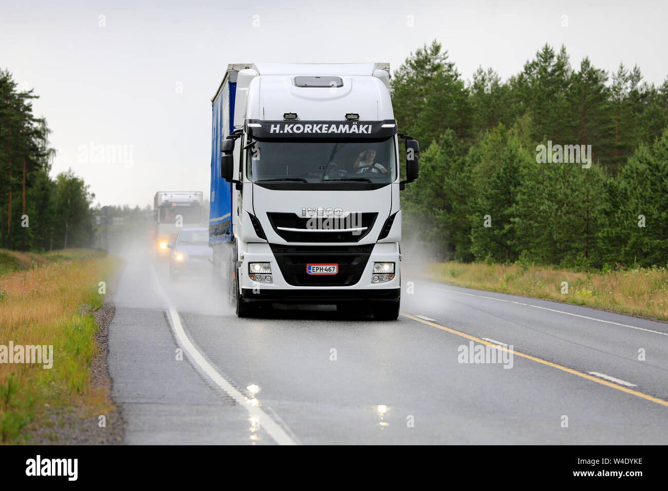 Raasepori, Finlandia. Julio 5, 2019. Blanco Stralis Iveco Truck pulls tráiler junto a la autopista 25 en húmedo lluvioso día de verano en el sur de Finlandia, vista delantera. Foto de stock