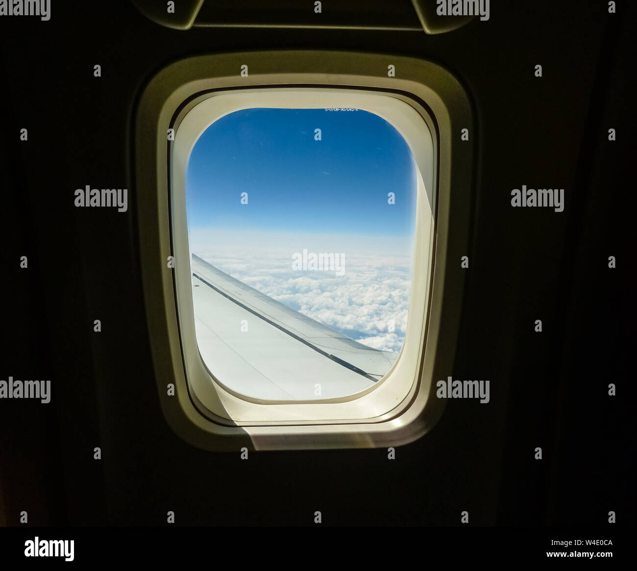 Ventana de aviones con vista aérea de aeronaves de ala y cielo con nubes Foto de stock
