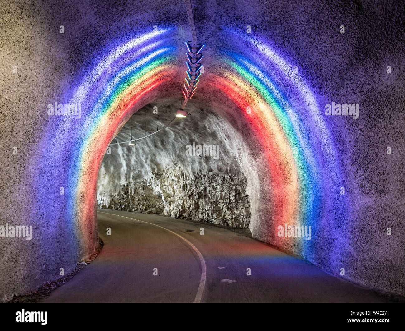 Colorido túnel iluminado para bicicletas y peatones conduce al puente colgante, Hardanger Hardanger, Noruega. Foto de stock