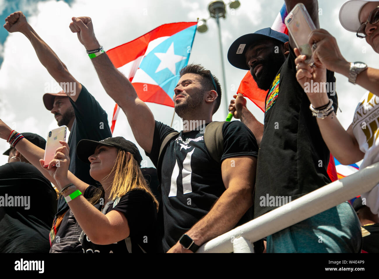 San Juan, Puerto Rico. El 22 de julio, 2019. Numerosas personas plantean  sus puños en una protesta contra el gobernador Rosselló. Los manifestantes  han estado exigiendo la renuncia del gobernador durante días.