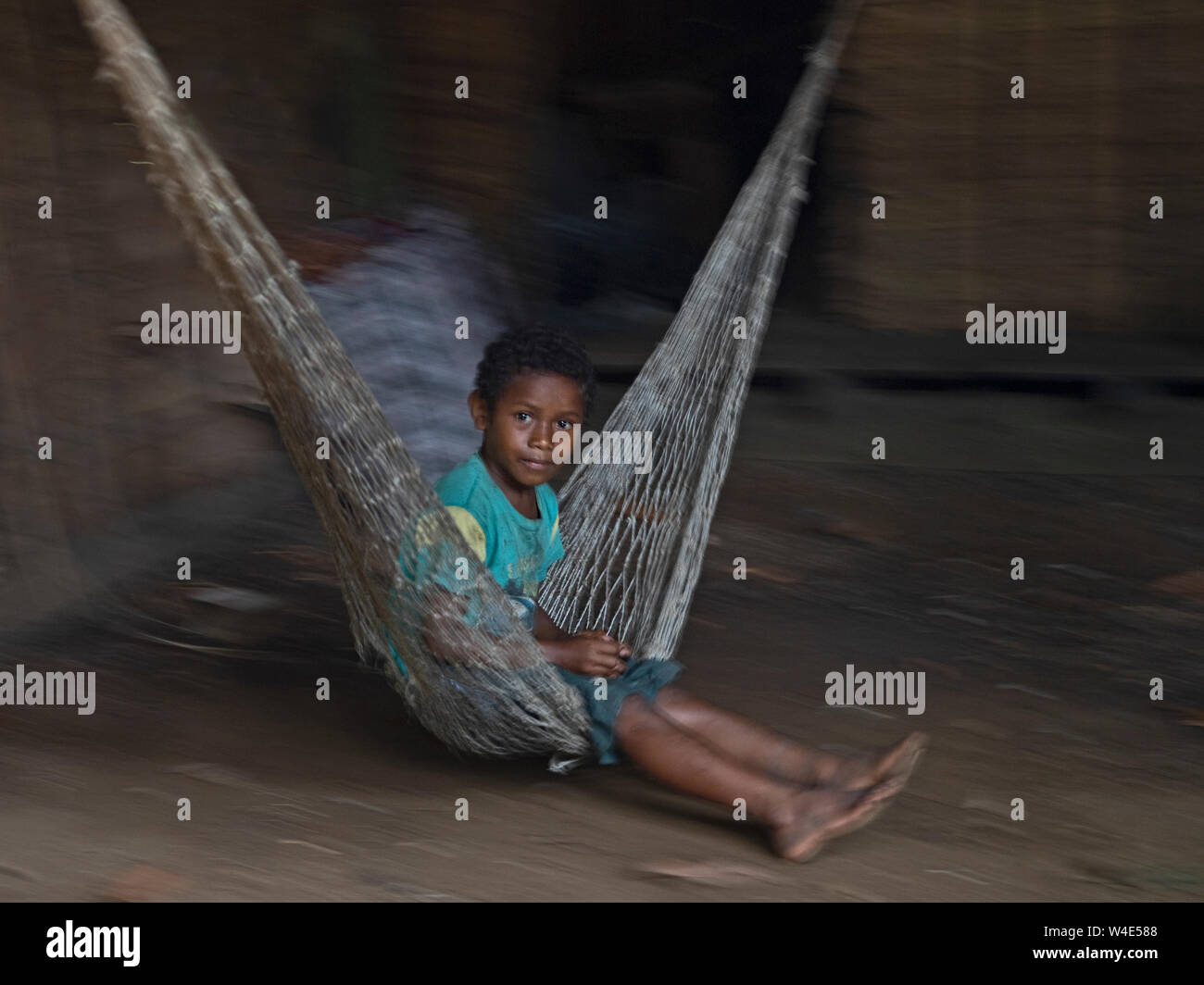 Chico se balanceen en hamaca en Nara aldea En Makira Island, al sur de las Islas Salomón Pacxific Foto de stock