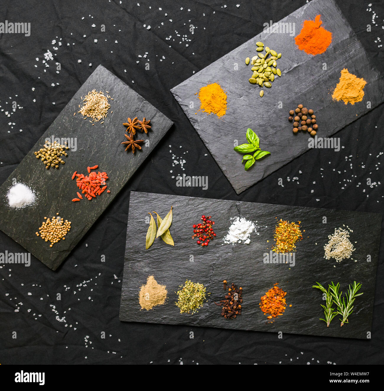 Gran selección de contraste colorido diferentes especias y semillas en la pizarra Foto de stock