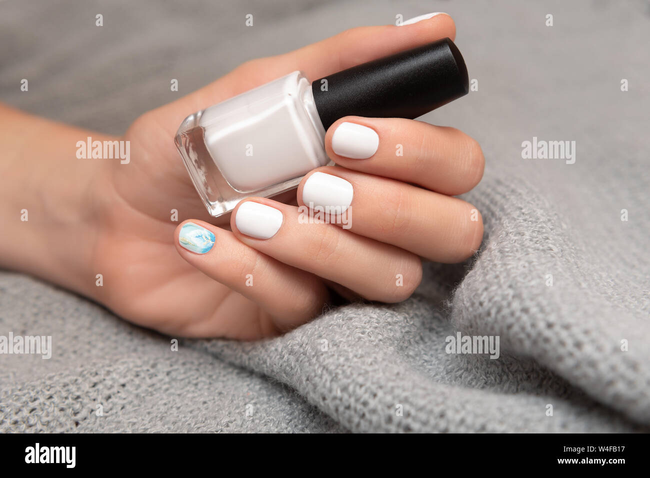 Lado Femenino Con El Diseno De La Una Blanca Sujetando La Botella De Esmalte De Unas Fotografia De Stock Alamy