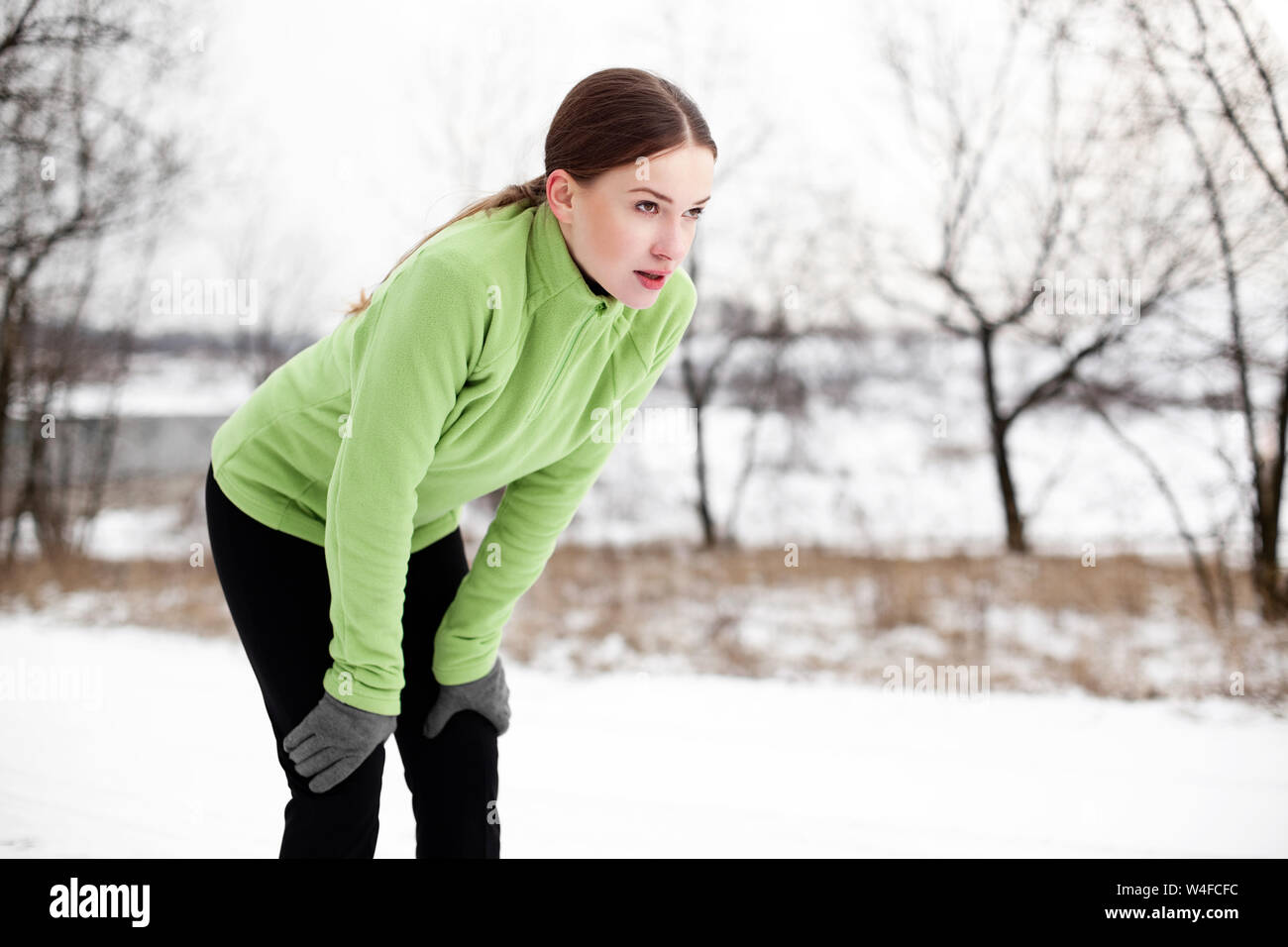 Mujer corriendo en invierno sendero de montaña banner de fondo.  Entrenamiento de atleta corredor cardio en clima frío al aire libre. Chica  asiática con leggings cálidos Fotografía de stock - Alamy