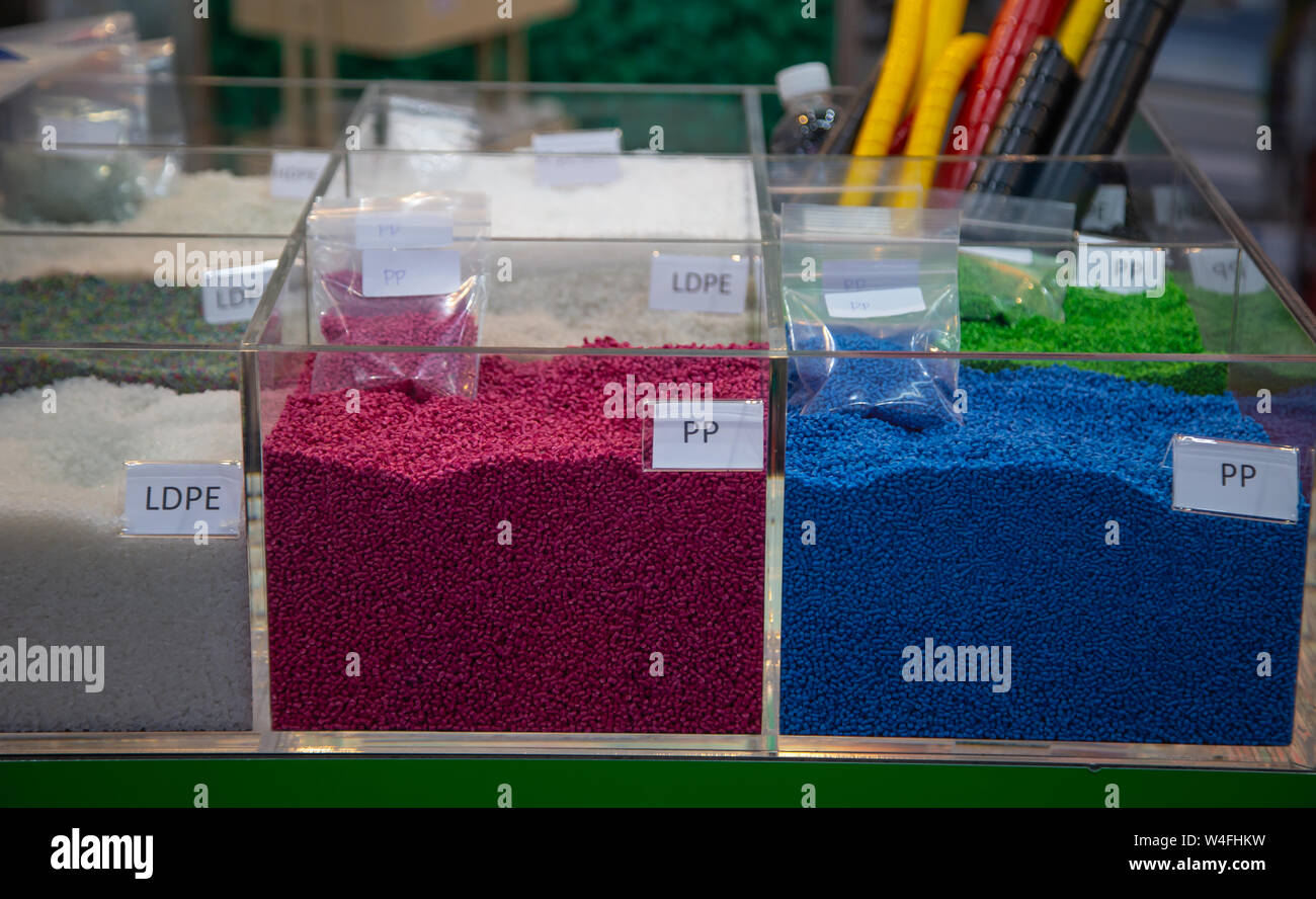 Colorido de gránulos de polímero plástico teñido en contenedores Foto de stock