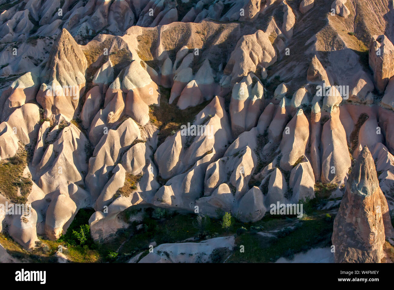 Coloridas formaciones rocosas situadas en la ladera de una colina cerca de Goreme, en la región de Cappadocia de Turquía. Eventualmente estas formaciones se convertirá en chimeneas de hadas Foto de stock